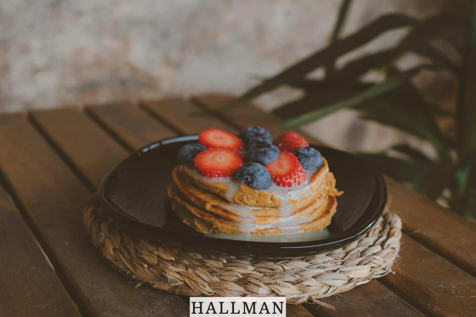 a stack of pancakes with strawberries and blueberries on top