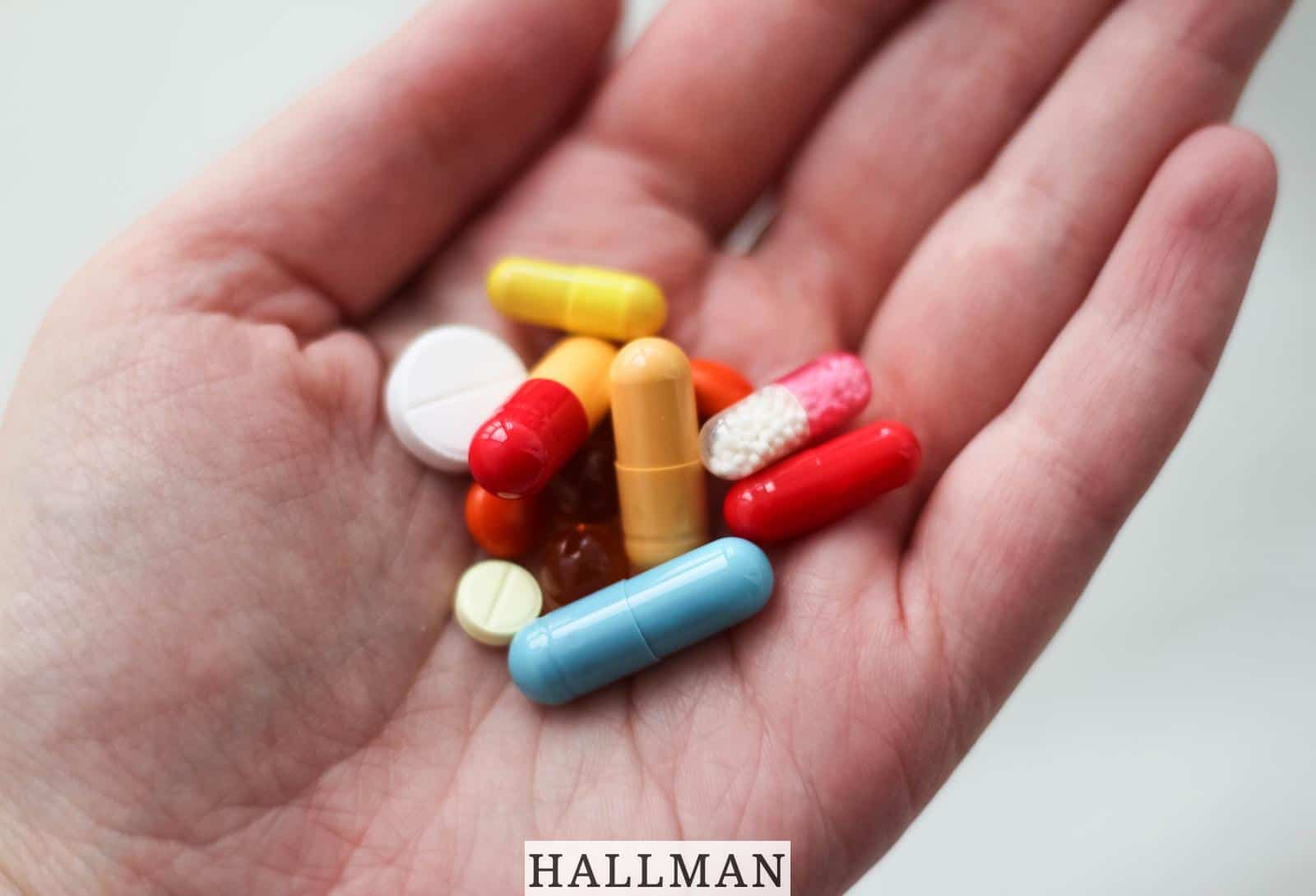 orange and white medication pill on persons hand